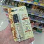 TrueMoney for Foreigners: How to Pay via QR Code Anywhere in Thailand (Even 7-Eleven!) Hand holding a Wangwan Medicated Oil roll-on pack in a Thailand 7-Eleven pharmacy aisle