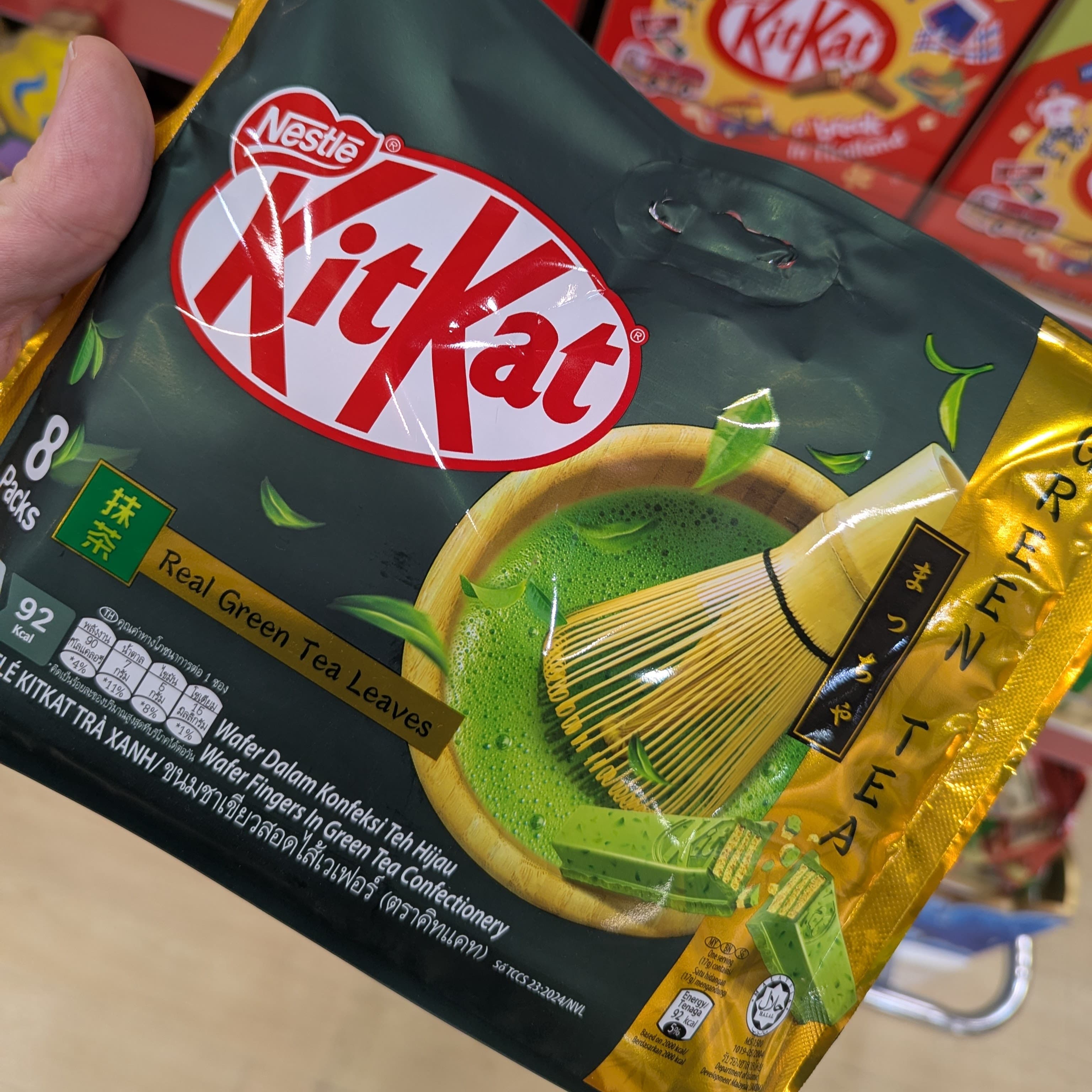 An open green tea KitKat bar on a 7-Eleven Thailand counter.