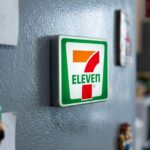 A detailed miniature 7-Eleven fridge magnet with LED lights glowing.