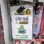 A sachet packet of Nazzly Lively Nose Premium Green Tea blackhead removal cream hanging on a store rack in Thailand.