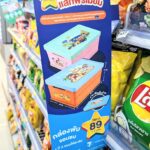 A blue vertical promotional display sign for the 7-Eleven ALL Member Crayon Shin-chan collapsible storage boxes on a store shelf in Thailand.