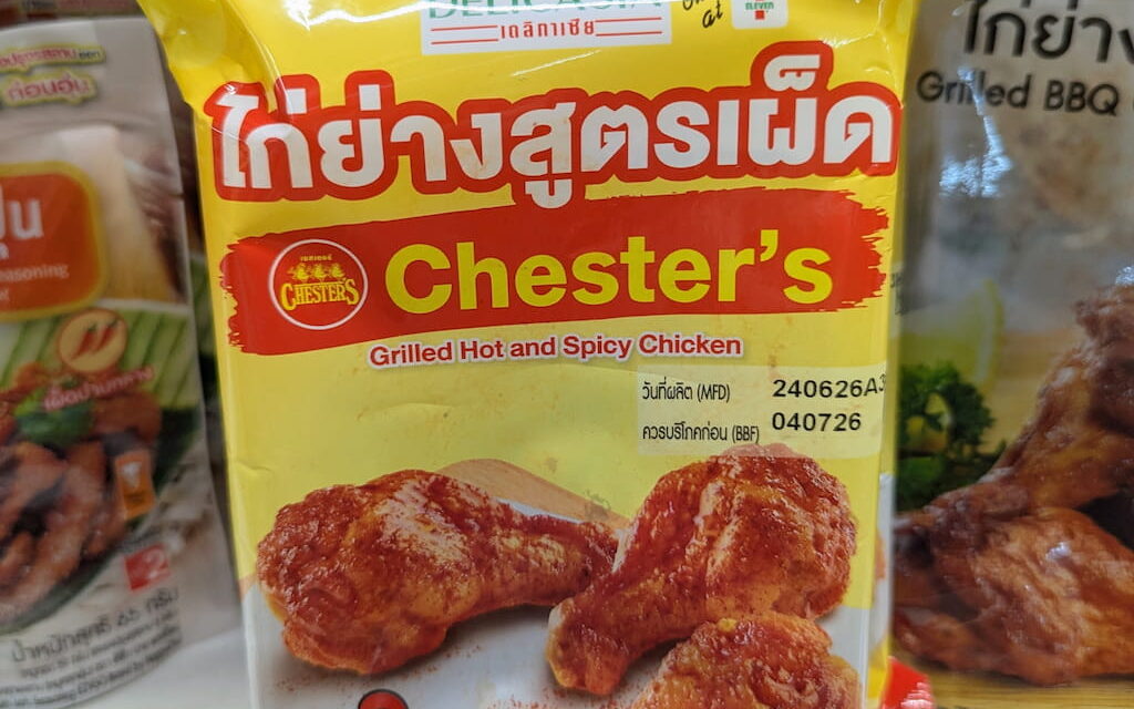 A yellow packaging pouch of Delicasia Chester's Grilled Hot and Spicy Chicken on a store shelf in Thailand.