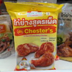 A yellow packaging pouch of Delicasia Chester's Grilled Hot and Spicy Chicken on a store shelf in Thailand.