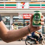 How to Buy Official 7-Eleven Thailand Merchandise: Products, Prices & ALL ONLINE Guide A man with a beer outside a 7 Eleven in Thailand