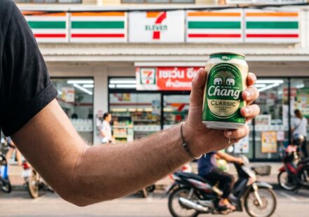The Ultimate Guide to Local Thai Beers at 7-Eleven: Complete List & ABV Breakdown A man with a beer outside a 7 Eleven in Thailand