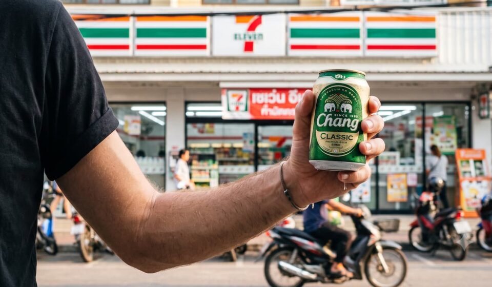 The Ultimate Guide to Local Thai Beers at 7-Eleven: Complete List & ABV Breakdown A man with a beer outside a 7 Eleven in Thailand