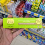 7-Eleven Thailand Giant Steamed Bao Bun Plush Pillow: Review & Foreigner Order Guide A hand holding a green box of Tepthai Concentrated Herbal Toothpaste Fresh Mint with Fluoride inside a 7-Eleven in Thailand.