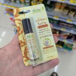 Pocari Sweat Ion Supply Drink: Essential Hydration for Tropical Heat & Post-Illness Recovery A hand holding a blister package of Wangwan Brand Medicated Oil Roll-On inside a 7-Eleven store in Thailand.