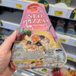 Ezygo Ebiko Mayonnaise Onigiri: A Crisp, Creamy Rice Snack That Hits the Spot Fresh A hand holding a package of Alfredo NEO PIZZA Extreme Chicken Sausage inside a 7-Eleven store in Thailand.