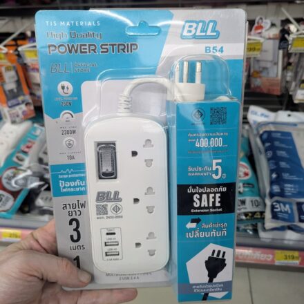 A hand holding a blister pack of BLL B54 High Quality Power Strip inside a 7-Eleven store in Thailand.