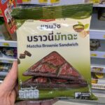 Ezygo Matcha Brownie Sandwich: A Hot, Surprise Sweet Toastie with Balanced Green Tea Earthines A hand holding a green and beige package of Ezygo Matcha Brownie Sandwich inside a 7-Eleven store in Thailand.