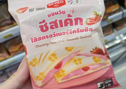 Ezygo Strawberry Cream Cheese Cheesecake Sandwich: A Sweet Dessert Toastie That Overpowers the Palate A hand holding a pastel pink package of Ezygo Strawberry Cream Cheese Cheesecake Sandwich inside a 7-Eleven store in Thailand.