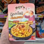 BLL B54 Power Strip Extension (3M): A Reliable, Safe Travel Lifesaver at 7-Eleven Thailand A hand holding a pink box of Reo's Deli Macaroni Cheese & Bacon inside a 7-Eleven store in Thailand.
